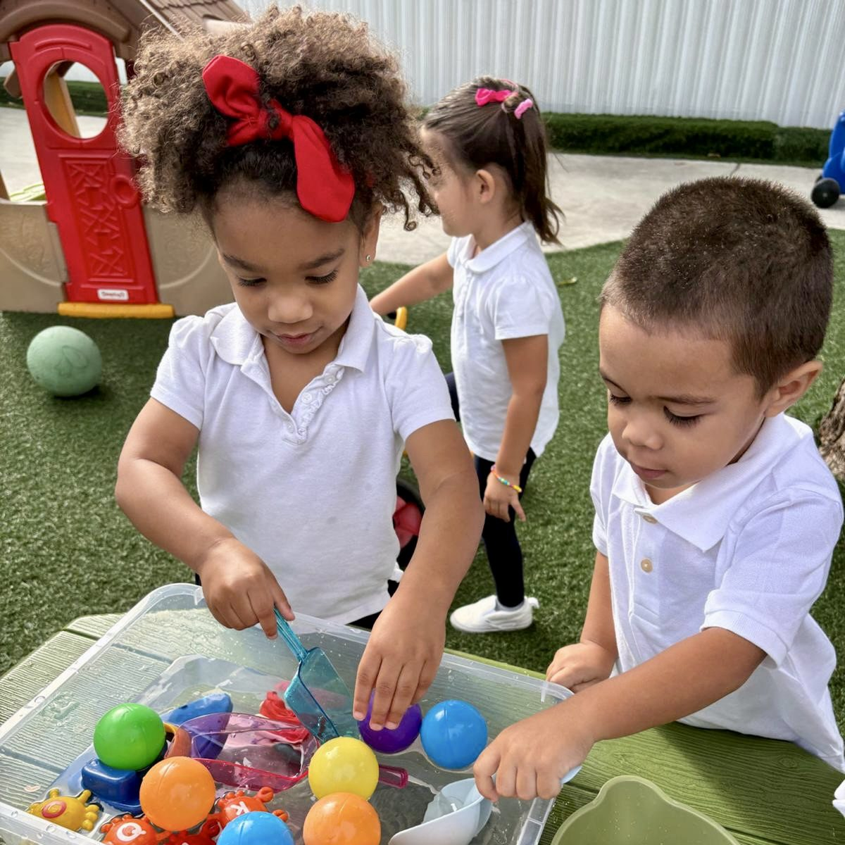 Children playing with colorful toys outside.