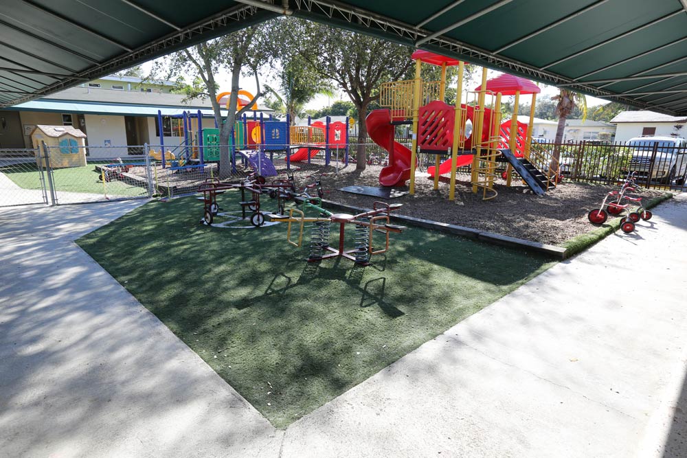 A playground with several different colored slides and swings.