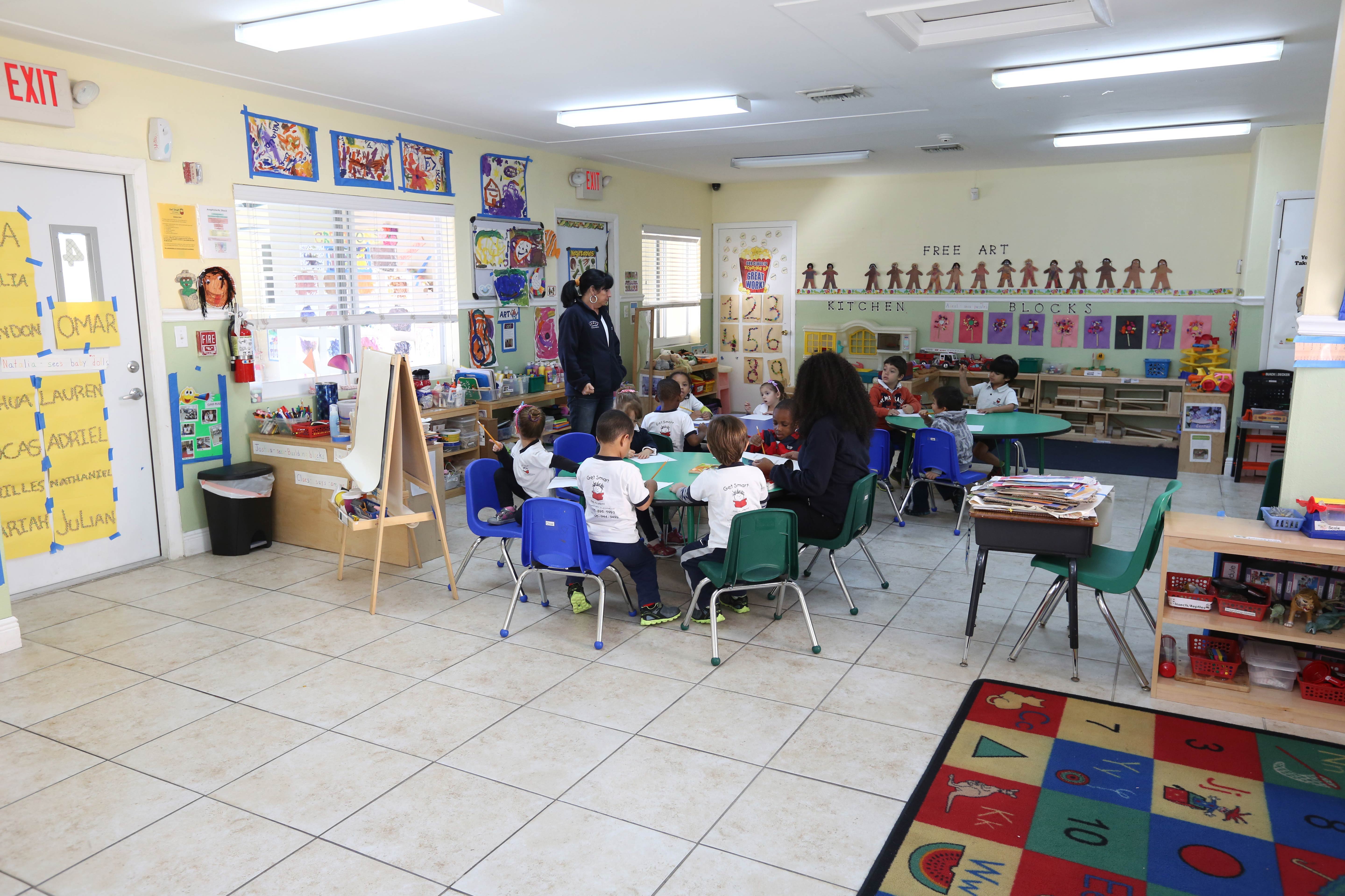 A group of children sitting at tables in a room.